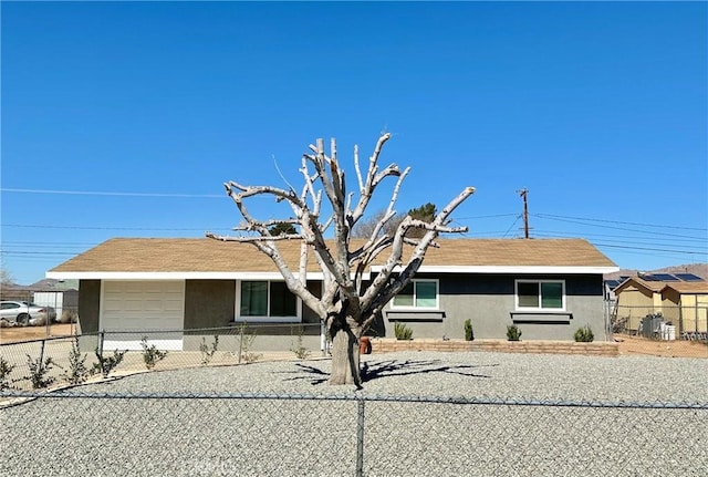 single story home featuring driveway, a fenced front yard, an attached garage, and stucco siding