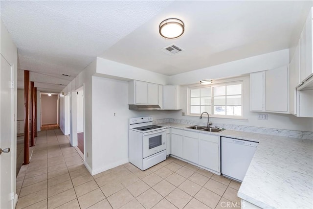 kitchen with white appliances, white cabinetry, light countertops, and a sink