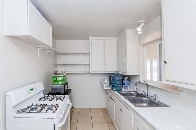 kitchen featuring light countertops, white range with gas stovetop, white cabinets, and a sink