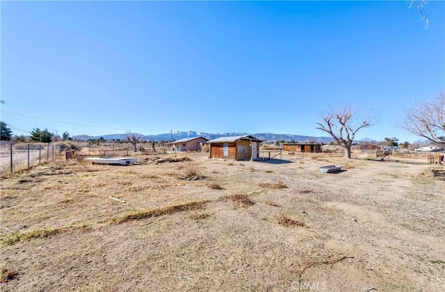 view of yard featuring fence and a mountain view