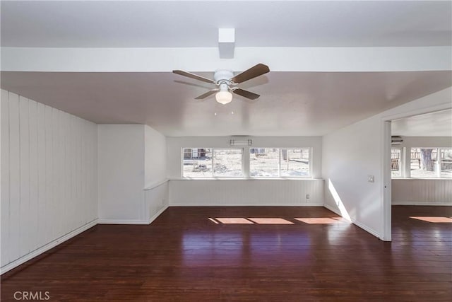 empty room featuring ceiling fan, baseboards, and wood finished floors