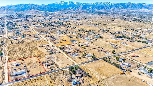 drone / aerial view featuring a mountain view and a desert view