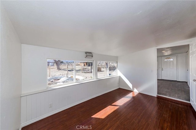 unfurnished room featuring baseboards and wood finished floors