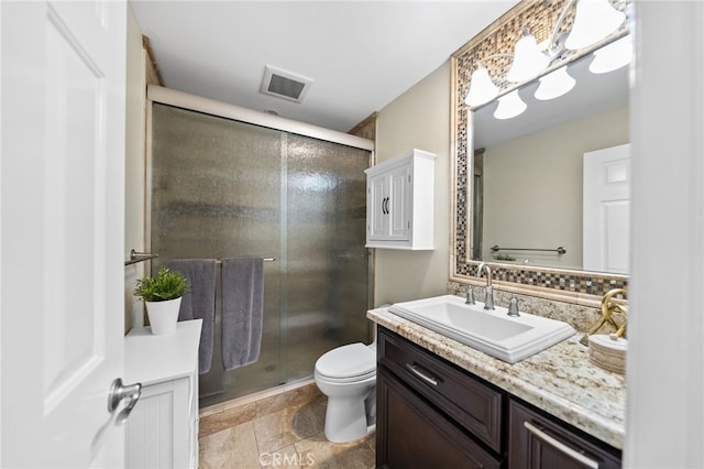 bathroom with toilet, vanity, visible vents, stone finish flooring, and a stall shower