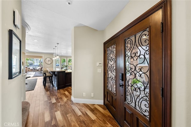 foyer entrance featuring baseboards and wood finished floors