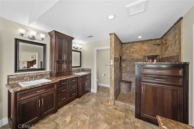 bathroom with a walk in shower, toilet, a sink, and visible vents