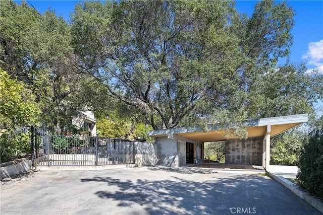 view of front of home with a carport, fence, and driveway