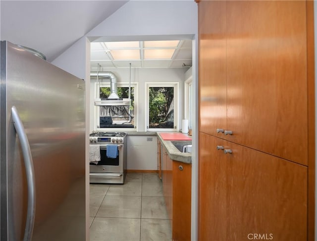 kitchen with appliances with stainless steel finishes, custom range hood, and light tile patterned floors