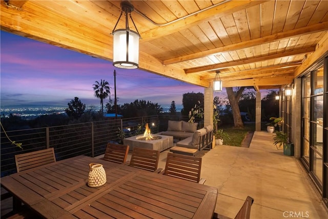 patio terrace at dusk with an outdoor living space with a fire pit and outdoor dining space