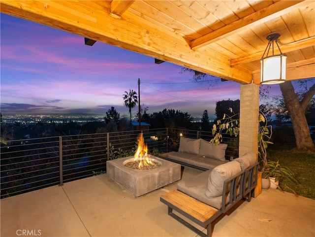 patio terrace at dusk with an outdoor living space with a fire pit