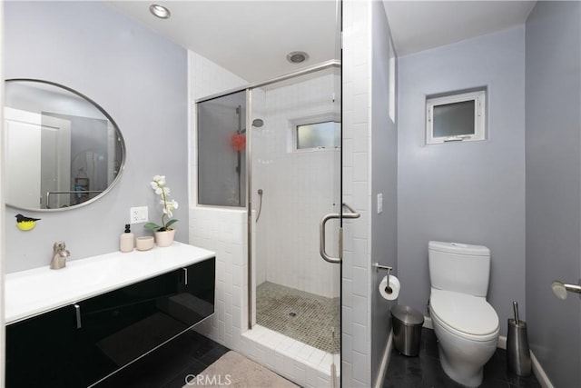 full bath with a stall shower, vanity, toilet, and baseboards