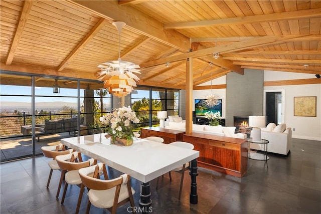 dining area featuring wood ceiling, a fireplace, a mountain view, and beam ceiling