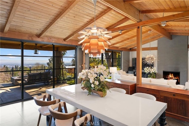 sunroom with vaulted ceiling with beams, ceiling fan with notable chandelier, a fireplace, and wood ceiling