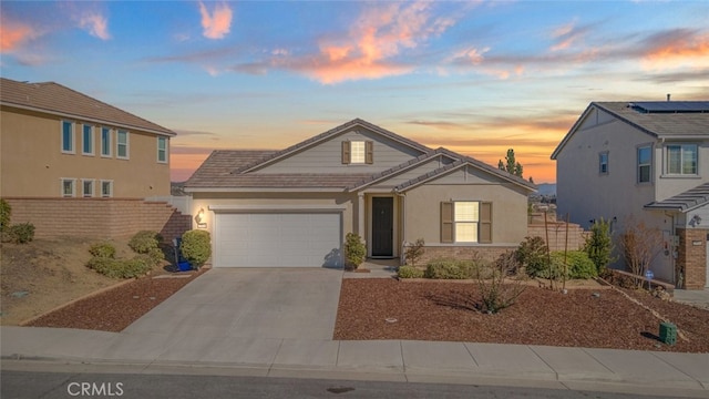 view of front of home with an attached garage, driveway, fence, and stucco siding