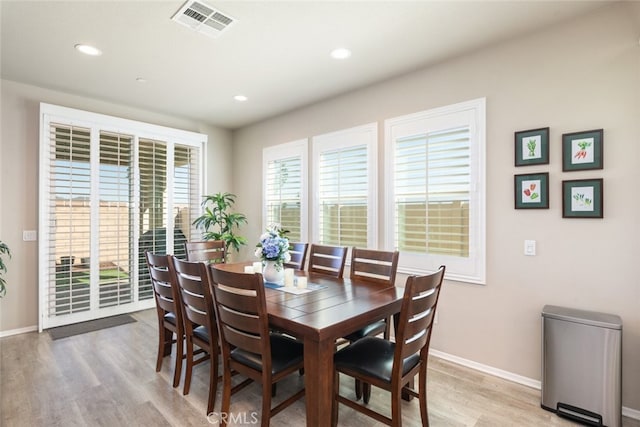 dining area with baseboards, visible vents, and light wood-style floors