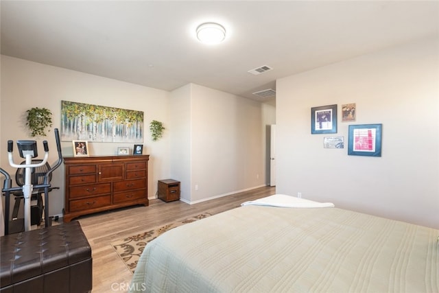 bedroom featuring light wood-type flooring, baseboards, and visible vents