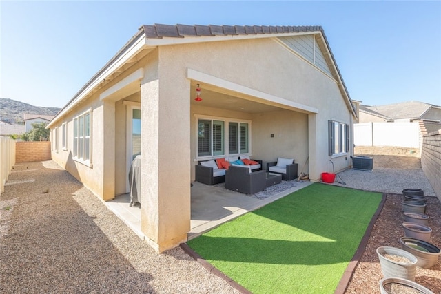 rear view of property featuring outdoor lounge area, a patio area, a fenced backyard, and stucco siding