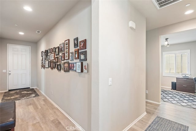 hallway with baseboards, visible vents, wood finished floors, and recessed lighting