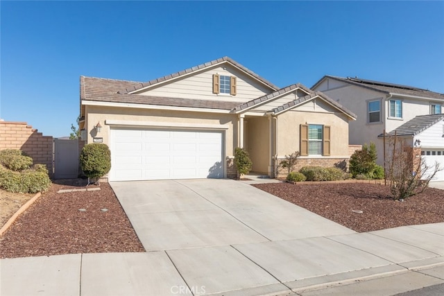 view of front of house featuring an attached garage, a tiled roof, concrete driveway, and stucco siding