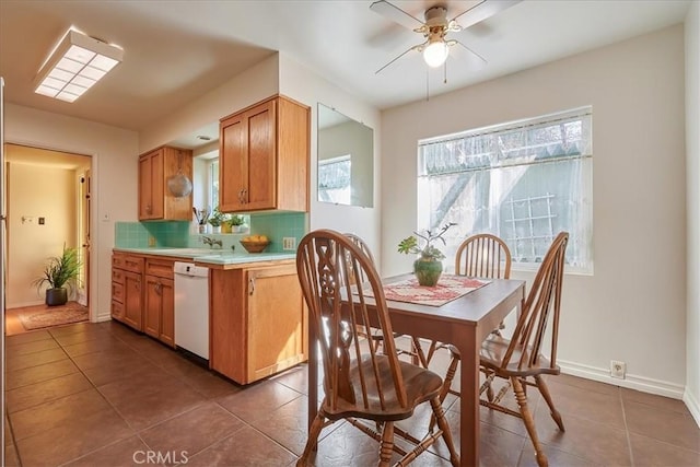 kitchen featuring light countertops, decorative backsplash, a ceiling fan, dishwasher, and dark tile patterned floors