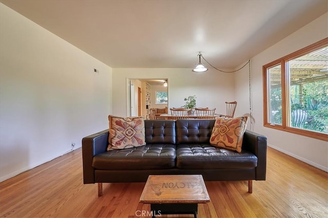 living area with visible vents, baseboards, and wood finished floors