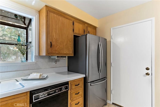 kitchen with dishwasher, light countertops, tasteful backsplash, and freestanding refrigerator