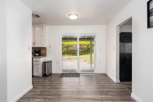 entryway featuring baseboards, visible vents, and dark wood-style flooring