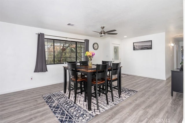 dining area with visible vents, baseboards, and wood finished floors