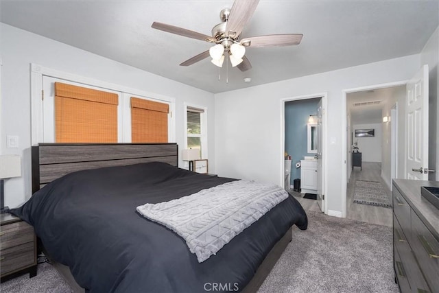 carpeted bedroom with visible vents, connected bathroom, and ceiling fan