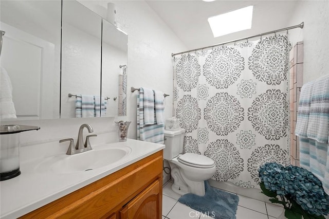 bathroom with a skylight, toilet, a shower with curtain, tile patterned flooring, and vanity