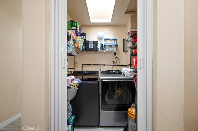 laundry area featuring laundry area, washer and clothes dryer, and a skylight