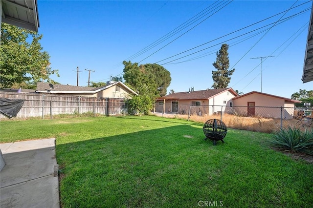 view of yard featuring an outdoor fire pit and a fenced backyard