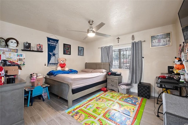 bedroom featuring a ceiling fan, baseboards, and wood finished floors