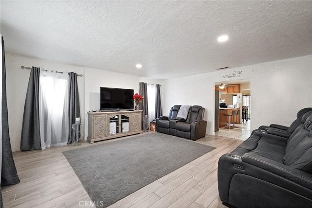 27447 Cypress St, Highland, CA 92346 - living room with healthy amount of natural light, a textured ceiling, light wood-style flooring, and recessed lighting