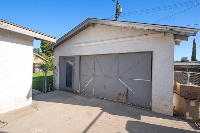 detached garage featuring fence