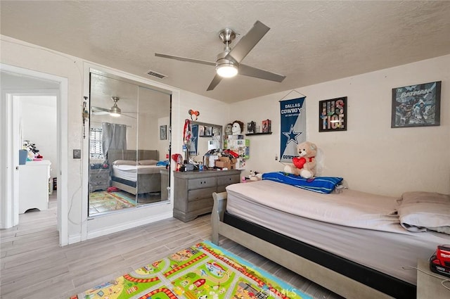 27447 Cypress St, Highland, CA 92346 - bedroom featuring light wood-style flooring, a textured ceiling, ceiling fan, and a closet