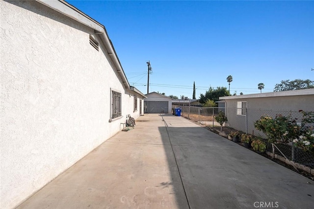 27447 Cypress St, Highland, CA 92346 - view of property exterior with stucco siding, fence, and a detached garage