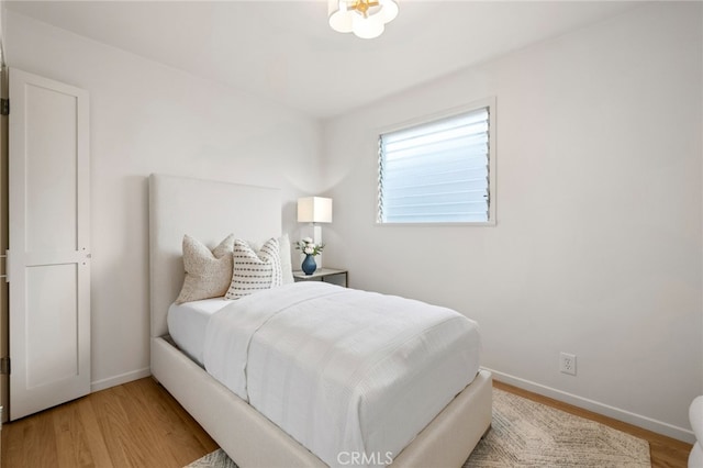 bedroom with light wood-type flooring and baseboards