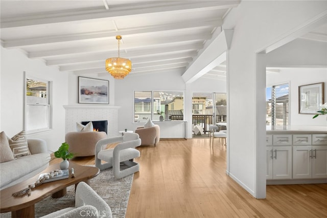 living area with light wood finished floors, a fireplace, and a healthy amount of sunlight