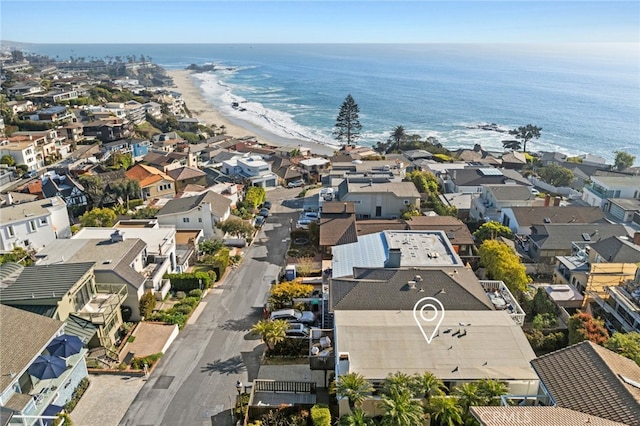 drone / aerial view featuring a water view, a residential view, and a beach view