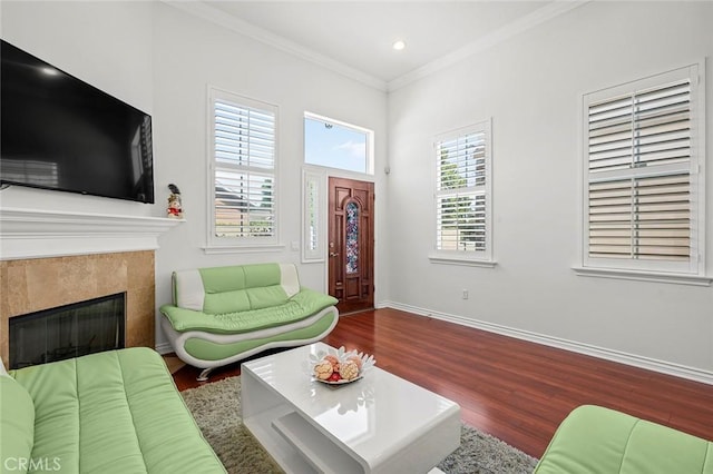 living room featuring baseboards, a tile fireplace, ornamental molding, wood finished floors, and recessed lighting