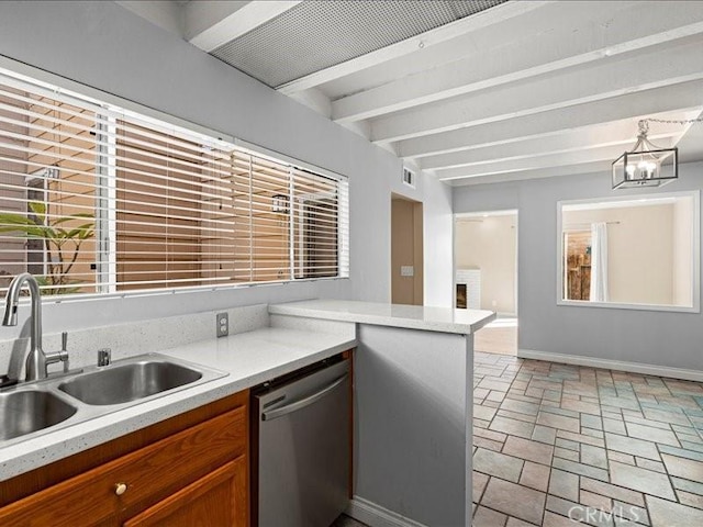 kitchen with a sink, baseboards, light countertops, stainless steel dishwasher, and stone tile flooring