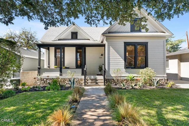 view of front of home featuring covered porch and a front lawn