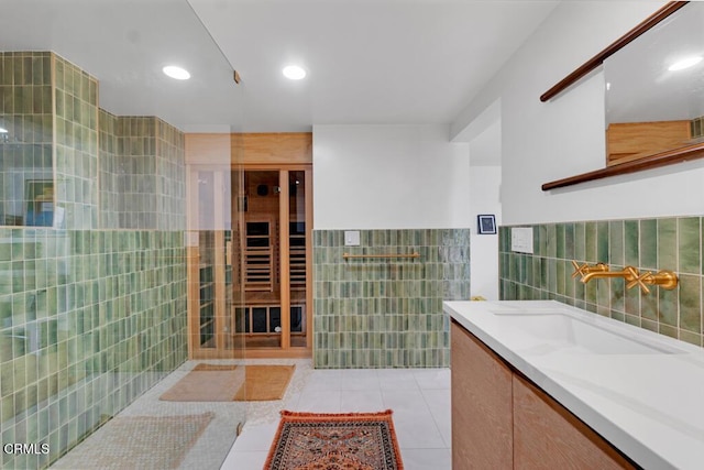 bathroom with tile patterned flooring, tile walls, vanity, and recessed lighting