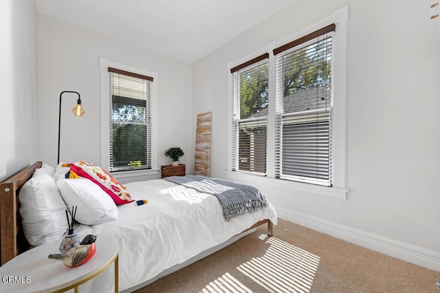 bedroom featuring carpet and baseboards