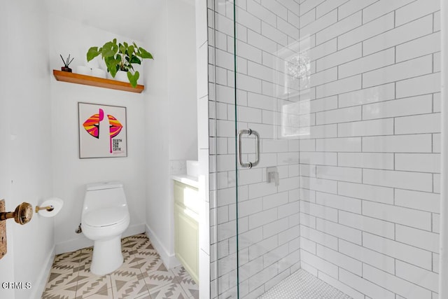 bathroom with a stall shower, tile patterned flooring, baseboards, and toilet