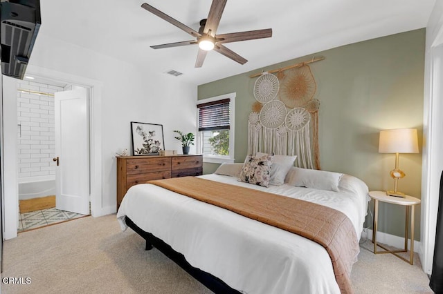 bedroom with ensuite bathroom, ceiling fan, light colored carpet, visible vents, and baseboards