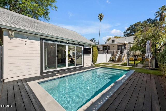 view of swimming pool with a fenced in pool, fence, and a wooden deck