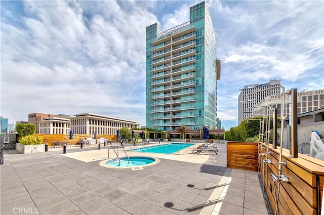 pool with a view of city, a patio, and a hot tub