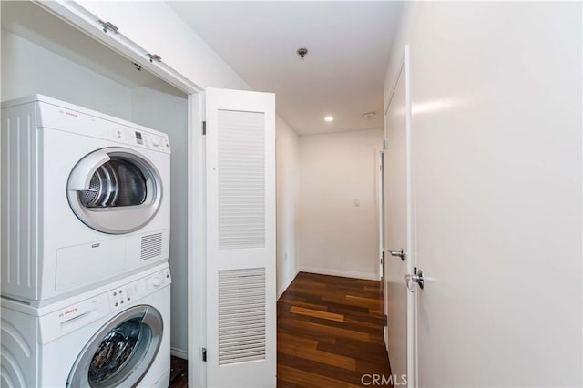 clothes washing area with recessed lighting, laundry area, wood finished floors, baseboards, and stacked washer / drying machine